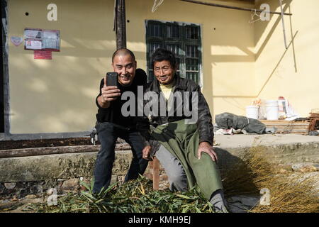 (171212) - NANCHANG, Dez. 12, 2017 (Xinhua) - Jiang Jinchun nimmt eine selfie mit einem Dorfbewohner, die er im Dorf Zaotian Hengfeng County geholfen hat, der ostchinesischen Provinz Jiangxi, Dez. 7, 2017. Jiang Jinchun, ein 39-jähriger Landwirt in der realen Welt, ist auch 'Bruder Jiang", die Live-übertragung und besitzt über 1,8 Millionen Fans im Internet. Von denjenigen, die ihre Talente oder Schönheit online, was Jiang Sendungen ist sein Leben im Dorf, einschließlich der Landschaft zeigen, die landwirtschaftlichen Produkte und die Änderung seiner Heimatstadt. Diese Praxis hat ihn sehr viele Kunden, die Stockfoto