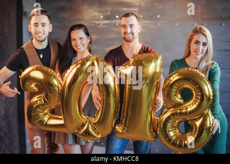 Zwei schöne junge Paare Spaß an der Silvesterparty, mit Karton Zahlen 2018. Stockfoto