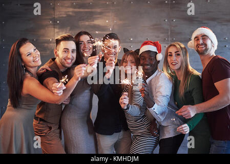 Party mit Freunden. Gruppe von fröhlichen jungen Menschen mit Wunderkerzen und Champagnergläser. Konzepte über die Jugend Zweisamkeit Lebensstil. Stockfoto