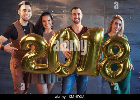 Zwei schöne junge Paare Spaß an der Silvesterparty, mit Karton Zahlen 2018 Stockfoto