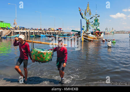 Jembrana, Insel Bali, Indonesien, September 20, 2015: in perancak Dorf Hafen indonesischen Dockers traditionellen Fischerboot entladen Stockfoto