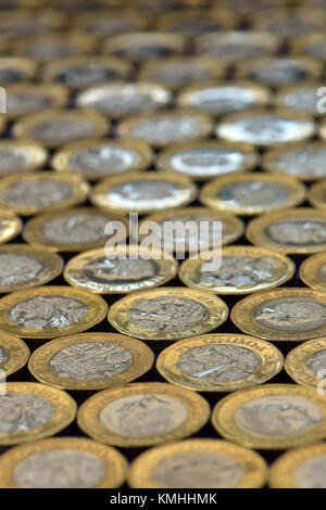 Eine große Anzahl oder eine Menge von einem Pfund Münzen festgelegten flach auf einer großen Oberfläche nach und nach Erlöschen des Fokus mit Schärfe im Vordergrund. einpfundstück Stockfoto