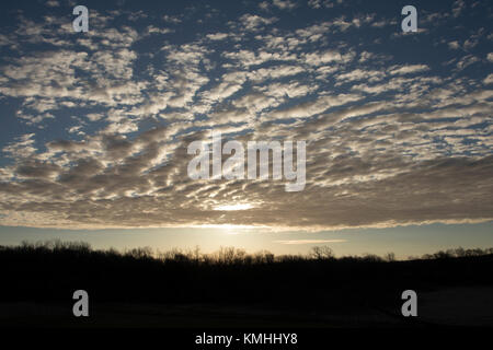 Wolken über einem Feld bei Sonnenaufgang Stockfoto