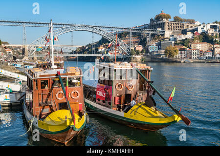 Traditionelle Rabelo Boote im Hafen Wein jetzt für Kreuzfahrten verwendet. Auf dem Douro Flussufer im Stadtteil Ribeira in Porto, Portugal. Mit dem Dom Lu Stockfoto