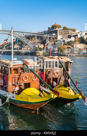 Traditionelle Rabelo Boote im Hafen Wein jetzt für Kreuzfahrten verwendet. Auf dem Douro Flussufer im Stadtteil Ribeira in Porto, Portugal. Mit dem Dom Lu Stockfoto