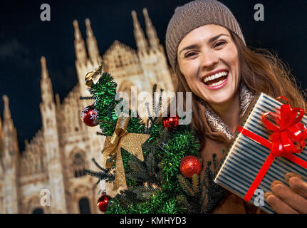 Spaß Weihnachten Reise nach Mailand, Italien. Freundliche moderne Frau mit Weihnachtsbaum und Geschenk in Mailand, Italien Stockfoto