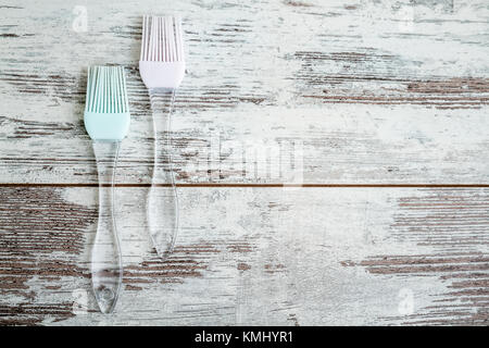 Silikon kochen Bürsten mit transparenten Griffe auf weißem Holz- Hintergrund Stockfoto