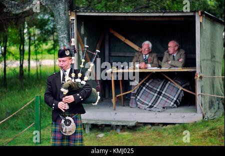 Dudelsack-Spieler und Richter bei Rohrleitungen Contest bei den Braemar Gathering Highland Games in Grampian Region von Schottland, Vereinigtes Königreich Stockfoto