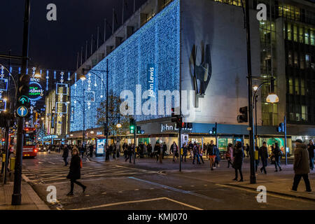 Weihnachtseinkäufer, die an Weihnachten am Kaufhaus John Lewis in der Oxford Street vorbeilaufen, London, Großbritannien Stockfoto