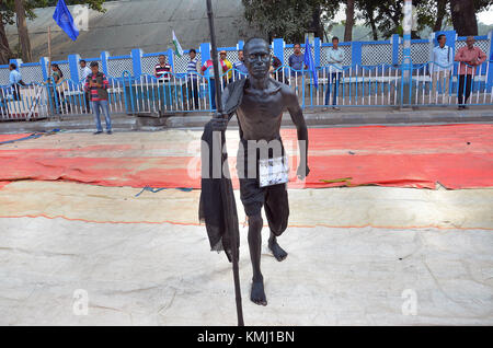 Kolkata, Indien. 06 Dez, 2017. Ein Mann, der als der Führer der indischen Unabhängigkeitsbewegung mahatma Mohandas Karamchand Gandhi in Dhoti und Stick auf der Straße gekleidet. Credit: sanjay purkait/Pacific Press/alamy leben Nachrichten Stockfoto