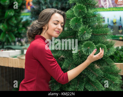 Glückliche Frau umarmt einen Weihnachtsbaum. Urlaub feiern das neue Jahr Stockfoto