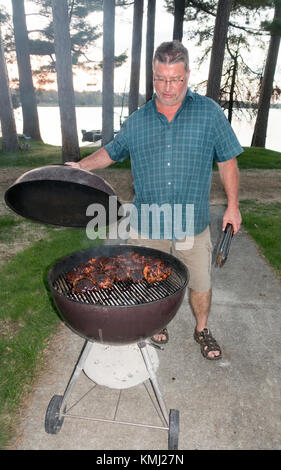 Huhnabendessen geröstet in einem Webber - wie Runde lidded Grill Minnesota Nisswa MN USA Stockfoto