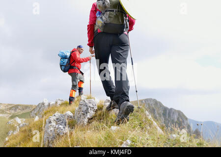 In der Nähe der Beine der junge Wanderer zu Fuß auf den Weg. Junges Paar trail aufwachen. Fokus auf Wanderschuhe Stockfoto