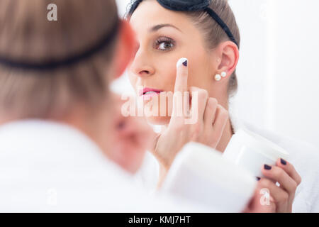 Frau mit Augenmaske und Bademantel in Ihrem Make-up entfernen, bevor Sie schlafen Stockfoto