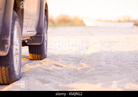 Pickup Truck am Strand Sand mit Boot im Hintergrund Stockfoto