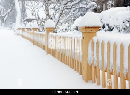 Gartenzaun, Gehweg und Pflanzen im Schnee während ein Wintersturm abgedeckt Stockfoto