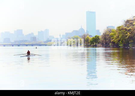 Nebeliger morgen in Boston. Ruderer in Charles River, City Skyline im Hintergrund. Stockfoto