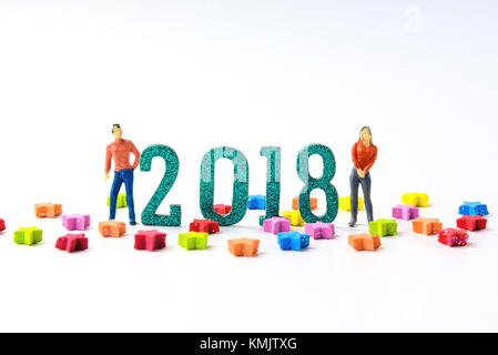 2018 Neues Jahr Konzept Mann und Frau miniatur Figuren stehen auf 2 0 1 8 Anzahl mit bunten Sternen auf weißen Hintergrund. Stockfoto