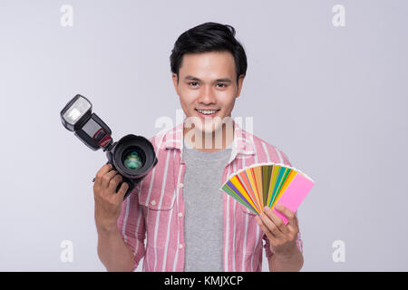 Jungen asiatischen Fotograf holding Digitalkamera, während im Studio arbeiten Stockfoto