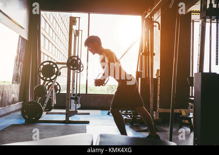 Fitness starker Mann, Schwere Übung auf der Maschine in der Turnhalle Stockfoto