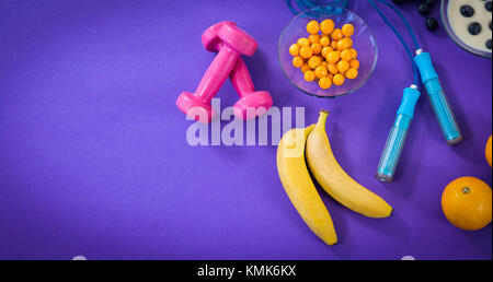 Hohe Betrachtungswinkel von Lebensmitteln mit übung Ausrüstung gegen lila Hintergrund Stockfoto