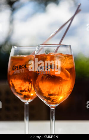 Zwei Gläser Aperol Spritz, eine Mischung aus Aperol, Prosecco und Sodawasser mit Orange, auf eine Tabelle in einer Bar. Stockfoto