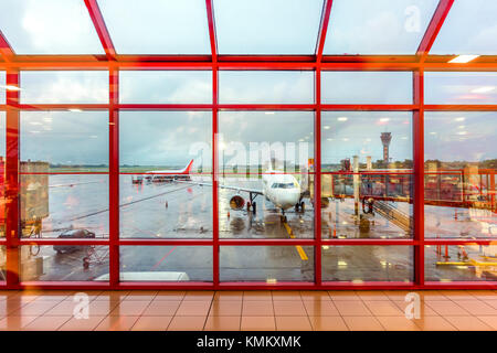 Blick von der rot-karierten Flughafen Fenster in den Morgen Flugplatz mit Flugzeugen Stockfoto