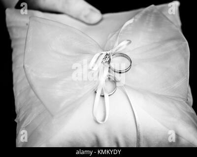 Die Hochzeit Ringe liegen auf dem Kissen in Schwarz und Weiß Stockfoto