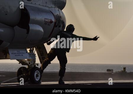 Ein U.S. Navy sailor bereitet eine U.S. Navy e-2c hawkeye Airborne Early Warning Flugzeuge für starten Sie das Flight Deck der US Navy Flugzeugträger der Nimitz-Klasse uss Theodore Roosevelt Dezember 2, 2017 in den Arabischen Golf. (Foto von Rachael treon über planetpix) Stockfoto