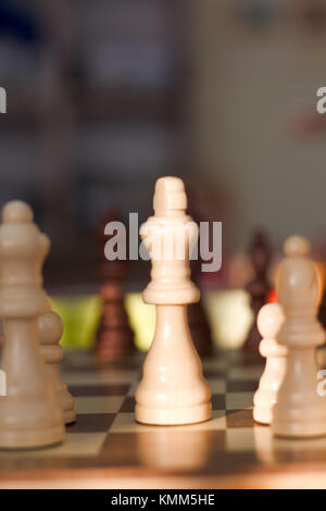 Weiß Schach quenn zeichnet sich vor dem Hintergrund auf einem Schachbrett Stockfoto