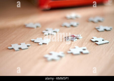 Unvollständige Puzzles auf Holztisch. Stockfoto