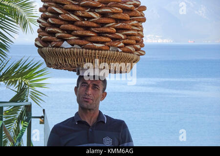 Türkische Mann balanciert simits auf Kopf, simit ist ähnlich einem Bagel, bedeckt mit Sesamsamen, Hafen im Kaleici, der Altstadt von Antalya, Türkische Rivier Stockfoto