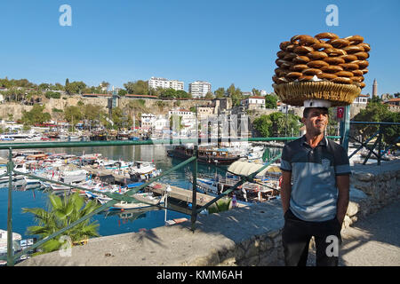 Türkische Mann balanciert simits auf Kopf, simit ist ähnlich einem Bagel, bedeckt mit Sesamsamen, Hafen im Kaleici, der Altstadt von Antalya, Türkische Rivier Stockfoto