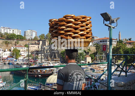 Türkische Mann balanciert simits auf Kopf, simit ist ähnlich einem Bagel, bedeckt mit Sesamsamen, Hafen im Kaleici, der Altstadt von Antalya, Türkische Rivier Stockfoto