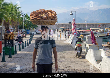 Türkische Mann balanciert simits auf Kopf, simit ist ähnlich einem Bagel, bedeckt mit Sesamsamen, Hafen im Kaleici, der Altstadt von Antalya, Türkische Rivier Stockfoto