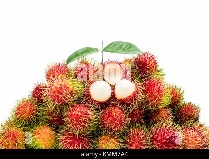 Nahaufnahme der Frische rote reife Rambutan (Nephelium lappaceum) mit Blättern auf weißem Hintergrund. Thailändisches Dessert süße Früchte. Tropische Früchte. Stockfoto