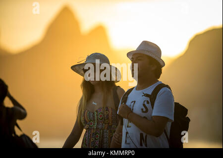 Rio de Janeiro - 21. Februar 2017: Ein junges Paar zu Fuß entlang der Promenade in arpoador, ein beliebter Ort, um den Sonnenuntergang Blick auf Ipanema Strand zu genießen. Stockfoto