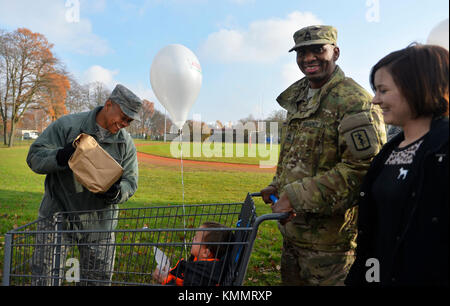 US Air Force Chief Master Sgt. Jackie Harris, 24th Intelligence Squadron Superintendent, links, lädt ein Thanksgiving Paket in einen Wagen während einer Veranstaltung, die von der United Services Organization auf Vogelweh Military Complex, Deutschland, 18. November 2017 gesponsert wird. Hochrangige angeritzte Führer aus mehreren Organisationen in der Kaiserslautern Militärgemeinde haben sich mit der USO zusammengetan, um Militärmitglieder, Gehaltsstufe E-5 und darunter, mit Thanksgiving Mahlzeiten zu versorgen. (USA Luftwaffe Stockfoto