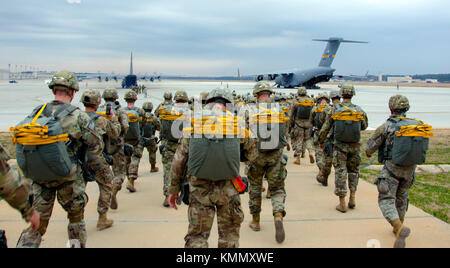 Fallschirmjäger, die an der Operation Toy Drop teilnehmen, begeben sich über das Pope Airfield auf eine C-17 Globemaster III, 2. Dezember 2017, Fort Bragg, North Carolina. Die 20. Jährliche Randy Oler Memorial Operation Toy Drop ist die weltweit größte kombinierte Luftoperation mit acht Partnernation Fallschirmjägern teilnehmen und erlaubt Soldaten die Möglichkeit, auf ihre militärische berufliche Spezialität trainieren, ihre Luftbereitschaft zu erhalten, und geben zurück an die lokale Gemeinschaft (USA Reserve Der Armee Stockfoto