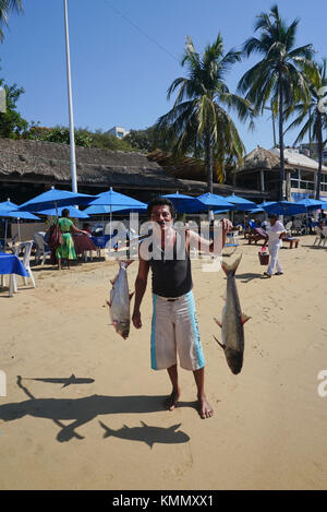 Mann, der frischen Fisch an der Playa Caletilla (Caletilla Beach) im alten Acapulco, Mexiko verkauft Stockfoto