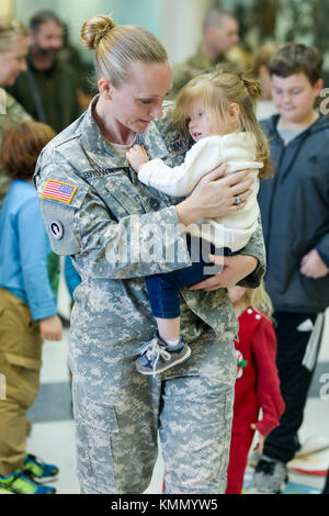 Heeresmeister Sgt. Sommer Brown, ein Operations NonCommissioned Officer, hält ihre Tochter während einer Veranstaltung im Hauptquartier und Hauptquartier Ablösung, Joint Force Headquarters 'Holiday Party in Raleigh, North Carolina, 3. Dezember 2017. Die Party beinhaltete einen Besuch vom Weihnachtsmann, Basteln für die Kinder, eine Leseecke und ein Feiertagsessen. (USA Nationalgarde Der Armee Stockfoto