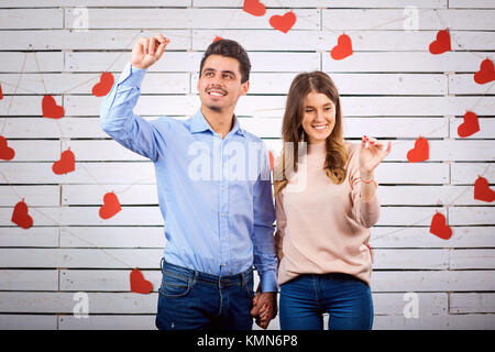 Ein liebevolles Paar zieht das Herz mit seinen Händen. Stockfoto