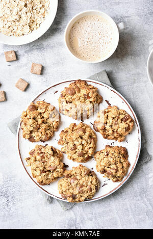 Frühstück mit gesunden oatmeal Cookies und Kaffee auf Tisch aus Stein. Ansicht von oben, flach Stockfoto