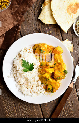 Chicken Curry mit Reis auf Holz- Hintergrund. Ansicht von oben, flach Stockfoto