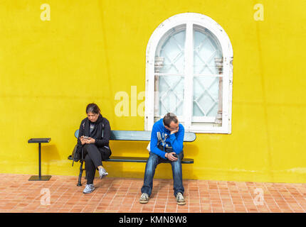 Zwei Menschen auf einer Bank in Portugal warten Stockfoto