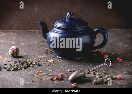 Blau Keramik Teekanne mit schwarzen und grünen Tee serviert Leben in dunklen Hintergrund. Chinesische Inschrift auf Teekanne - traditionelle Kaffee trinken Stockfoto