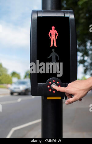 Hand Druck auf den Knopf an der Fußgängerampel Stockfoto