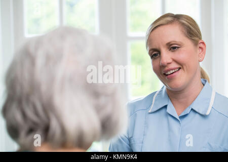 Care Worker im Gespräch mit älteren Frau zu Hause Stockfoto