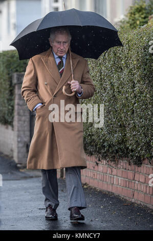 Der Prinz von Wales verwendet einen Regenschirm, während er zu seinem Nächsten Termin an der Abbeyfield Gehäuse Service unterstützt, nach seinem Besuch in den Caerphilly Bergleute Community Center in Caerphilly. Stockfoto