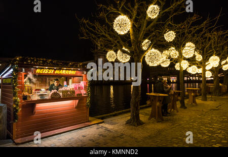 Luzern, Schweiz - 2 Dec 2017: ein Verkäufer der traditionelle heiße Kastanien (Marroni) wartet auf Kunden in seinem stand draußen auf der Straße. Stockfoto